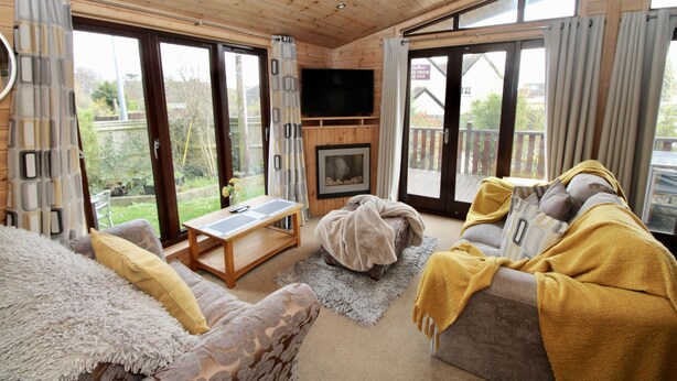 A cozy living room with a fireplace, a sofa, a table, and a TV.
