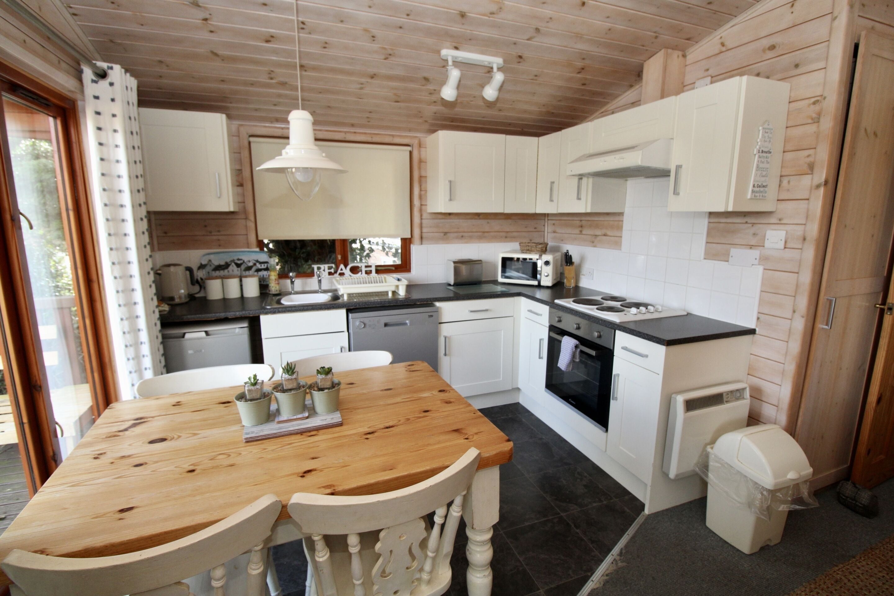 A kitchen with wooden cabinets, a wooden table, and a sink.