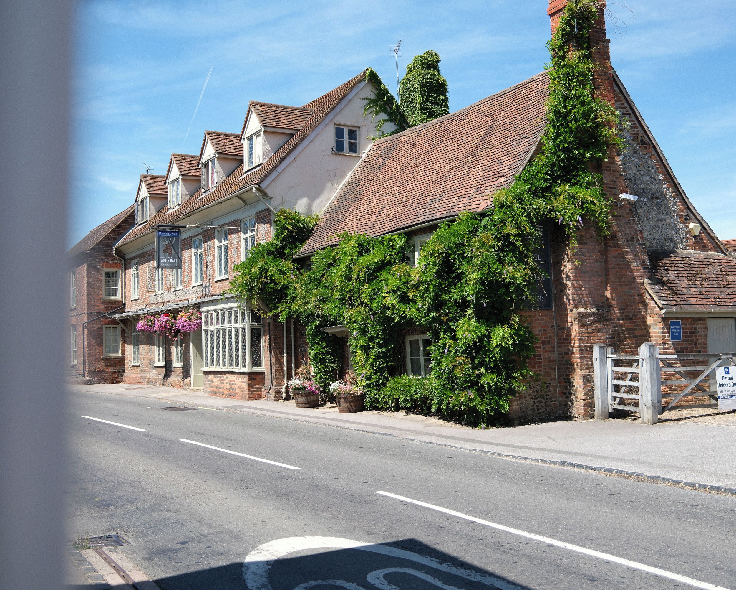 A traditional building with a brick facade, a tiled roof, and a sign indicating a pub.