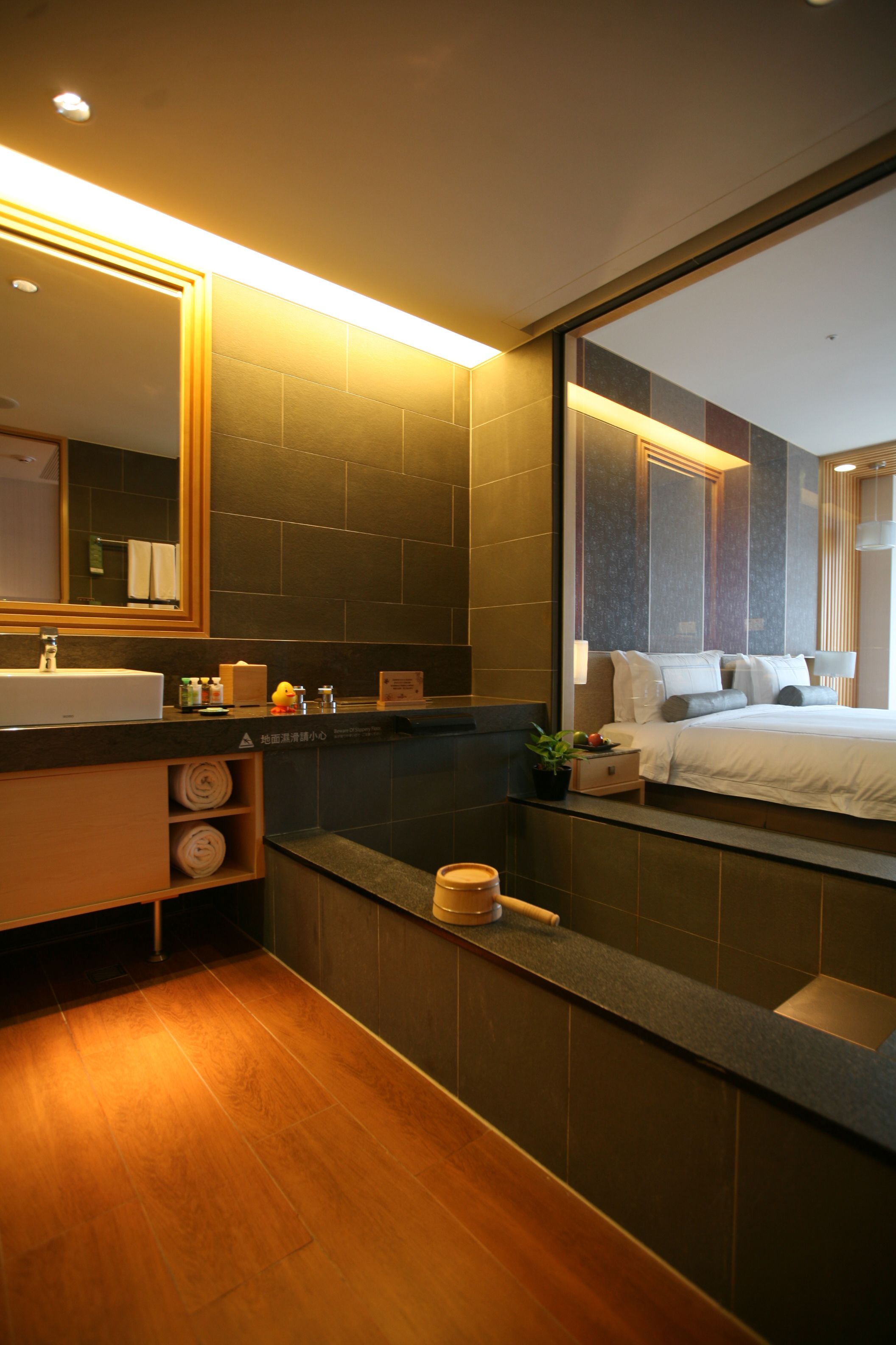 A modern bathroom with a large mirror, a sink, and a bathtub.
