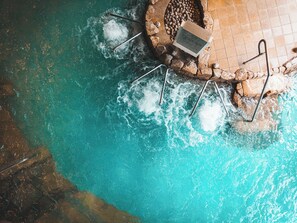 Ein Pool mit Steinkante und Metallleiter.