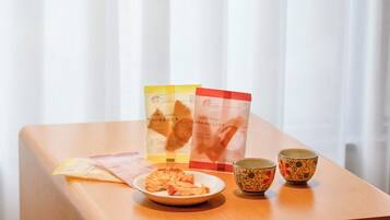 Ett träbord med en tallrik torkade snacks, två koppar och informationsbroschyrer.