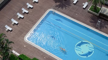 Una piscina al aire libre, sillones reclinables de piscina
