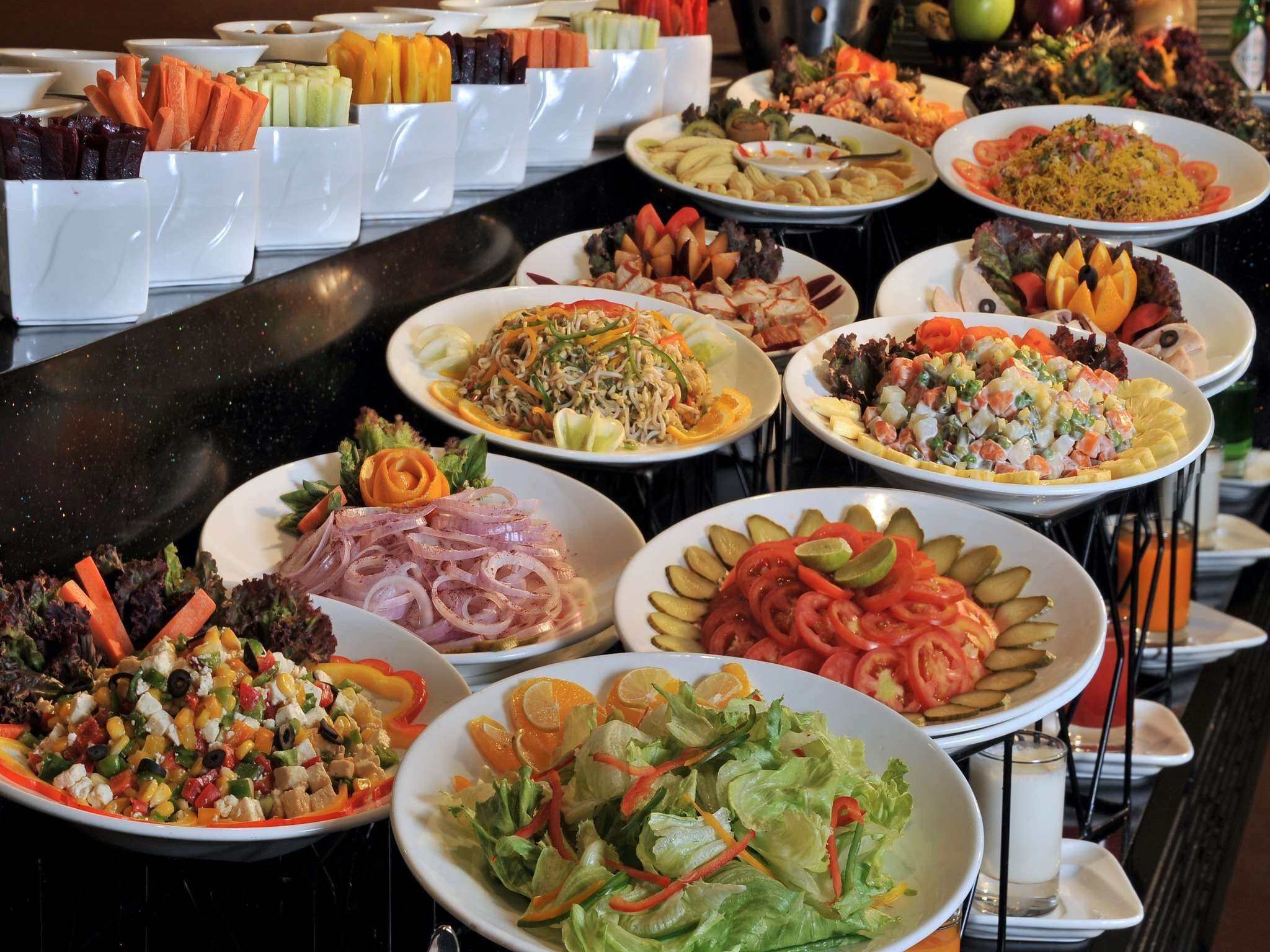A buffet with various dishes including salads, meats, and vegetables.
