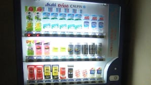 A vending machine with multiple beverage options, including sodas and energy drinks. - Enagic Okinawa International Plaza Hotel (Naha)