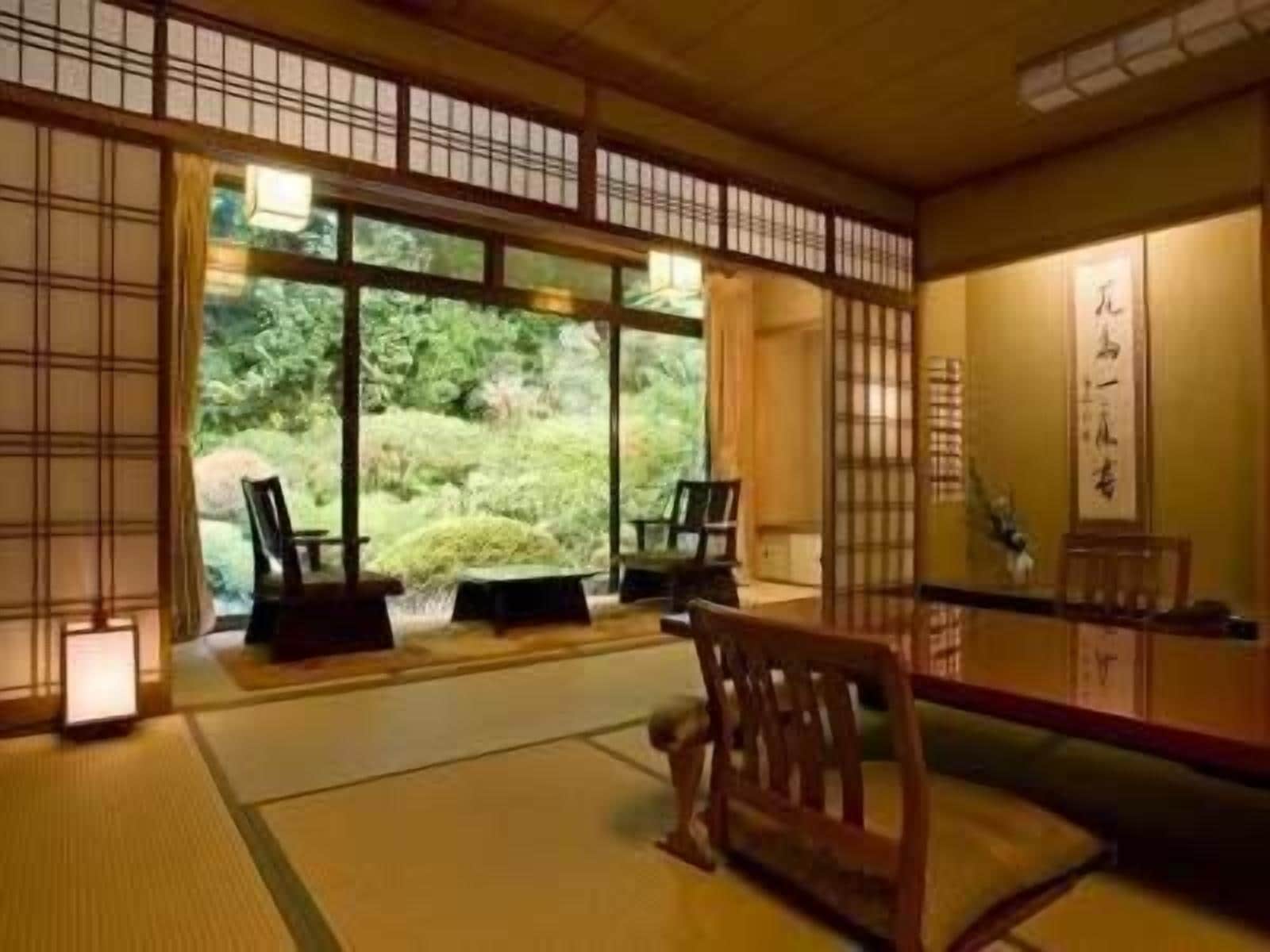 Una habitación japonesa tradicional con suelo de tatami, puertas correderas y vistas a un jardín exuberante.