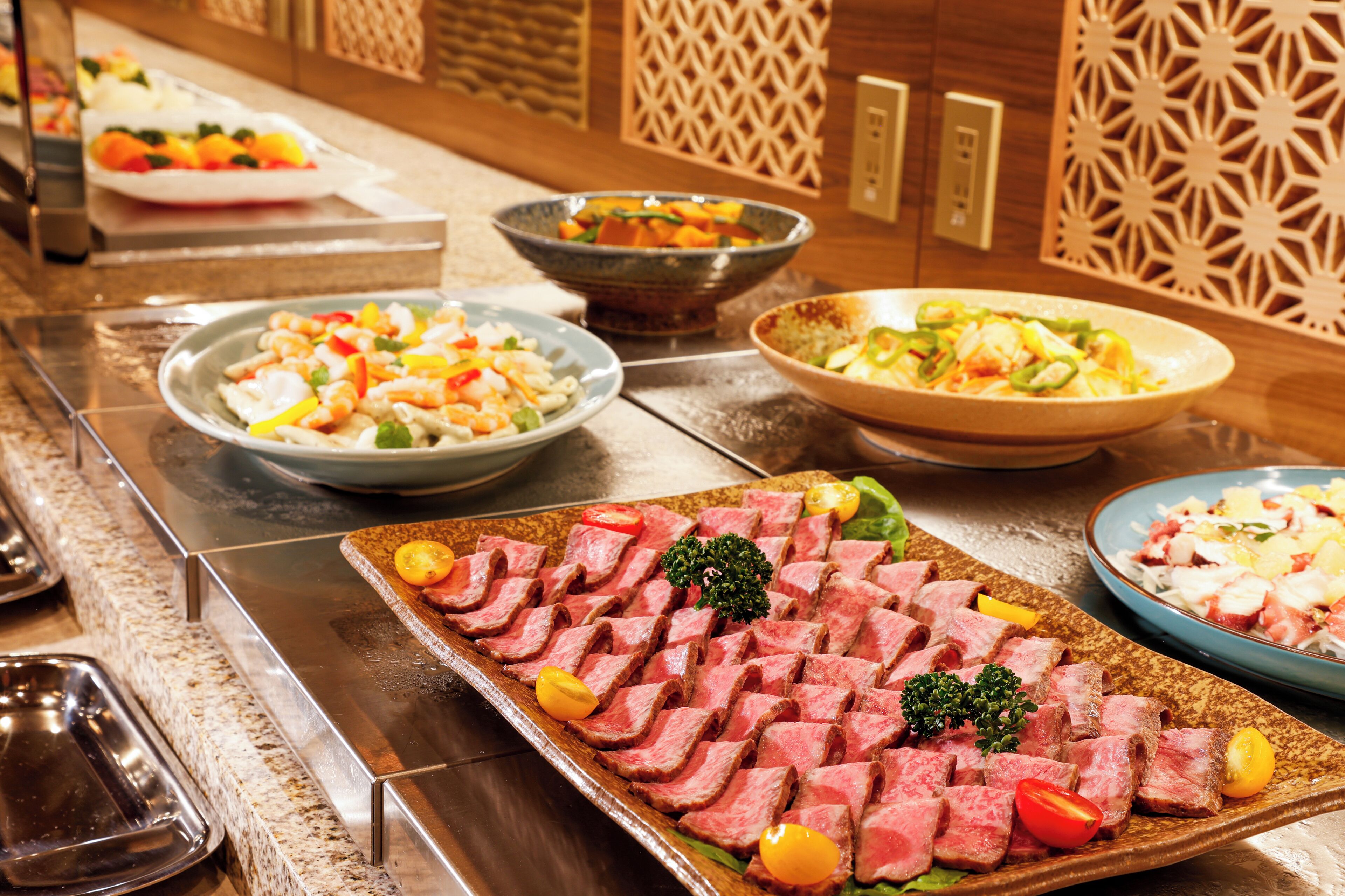 A buffet with various dishes including sliced meat, salads, and vegetables.