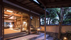 Un edificio de estilo japonés tradicional con suelo de esteras de tatami, una escalera de piedra y un farol.