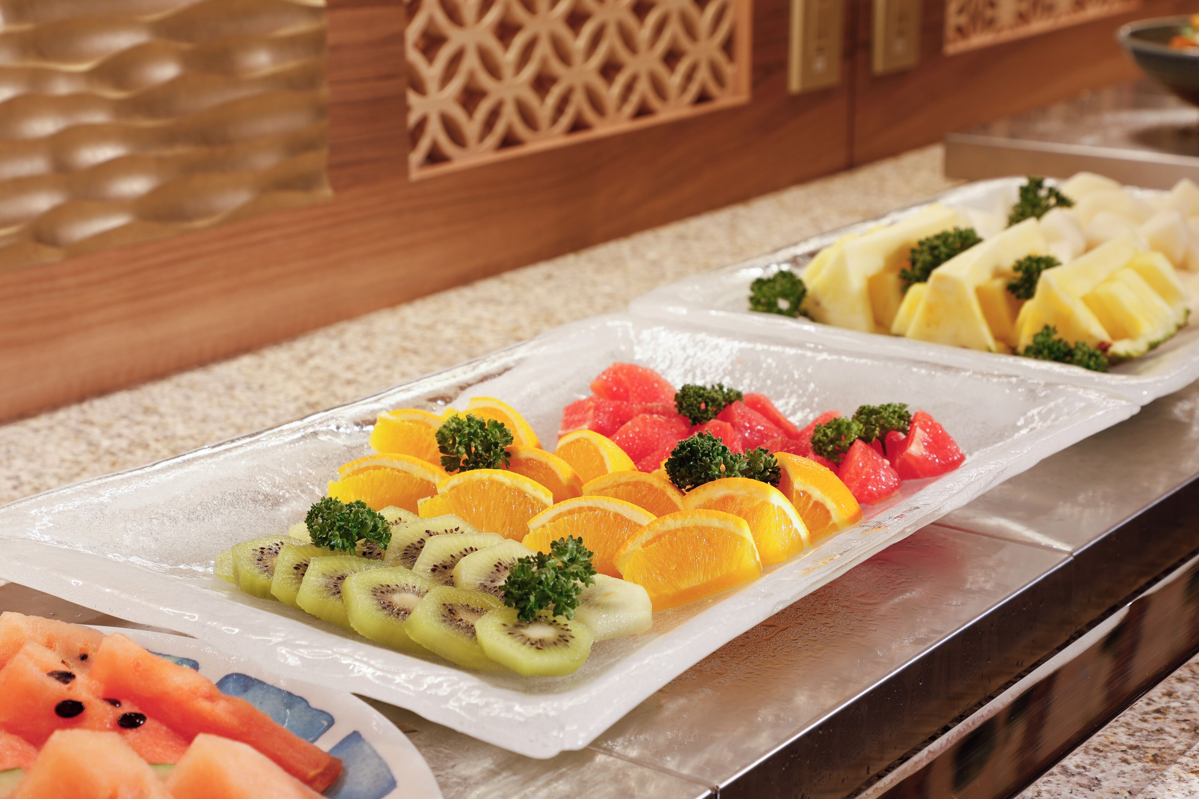 A buffet with various fruits and vegetables arranged on a tray.