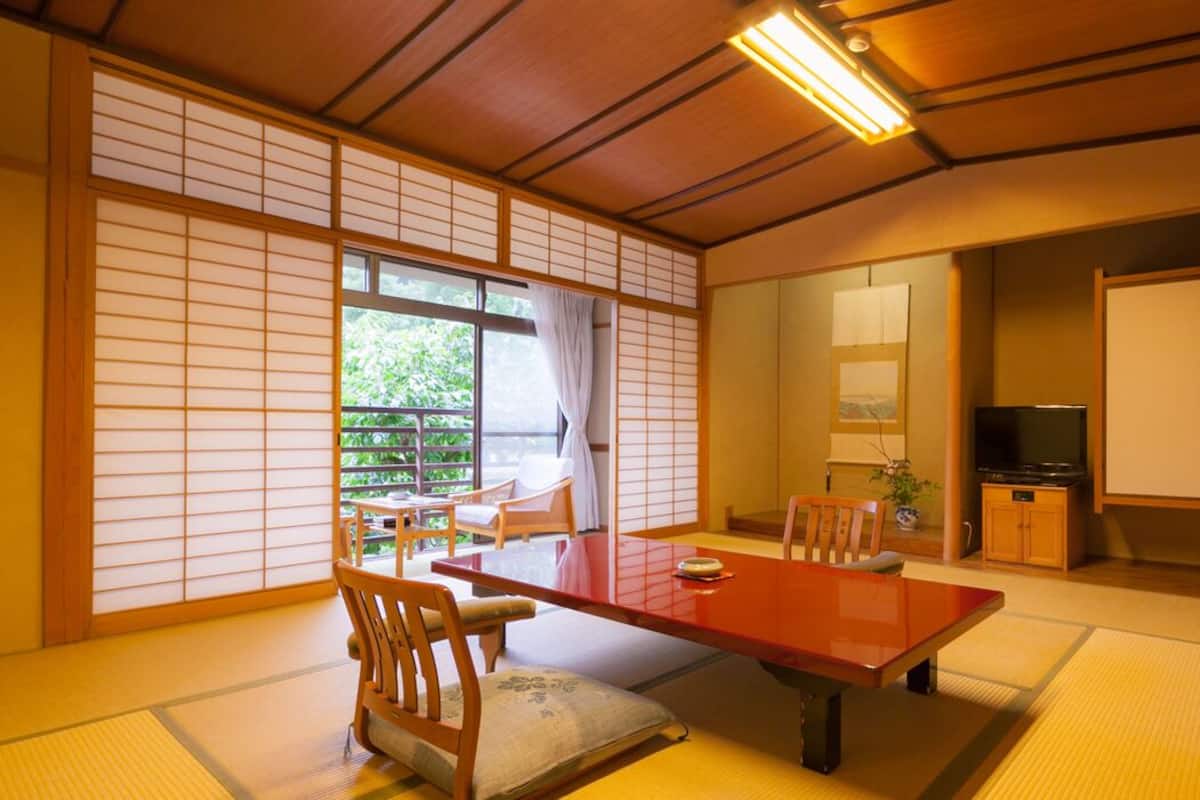 A traditional Japanese room with tatami flooring, a low wooden table, and sliding doors.