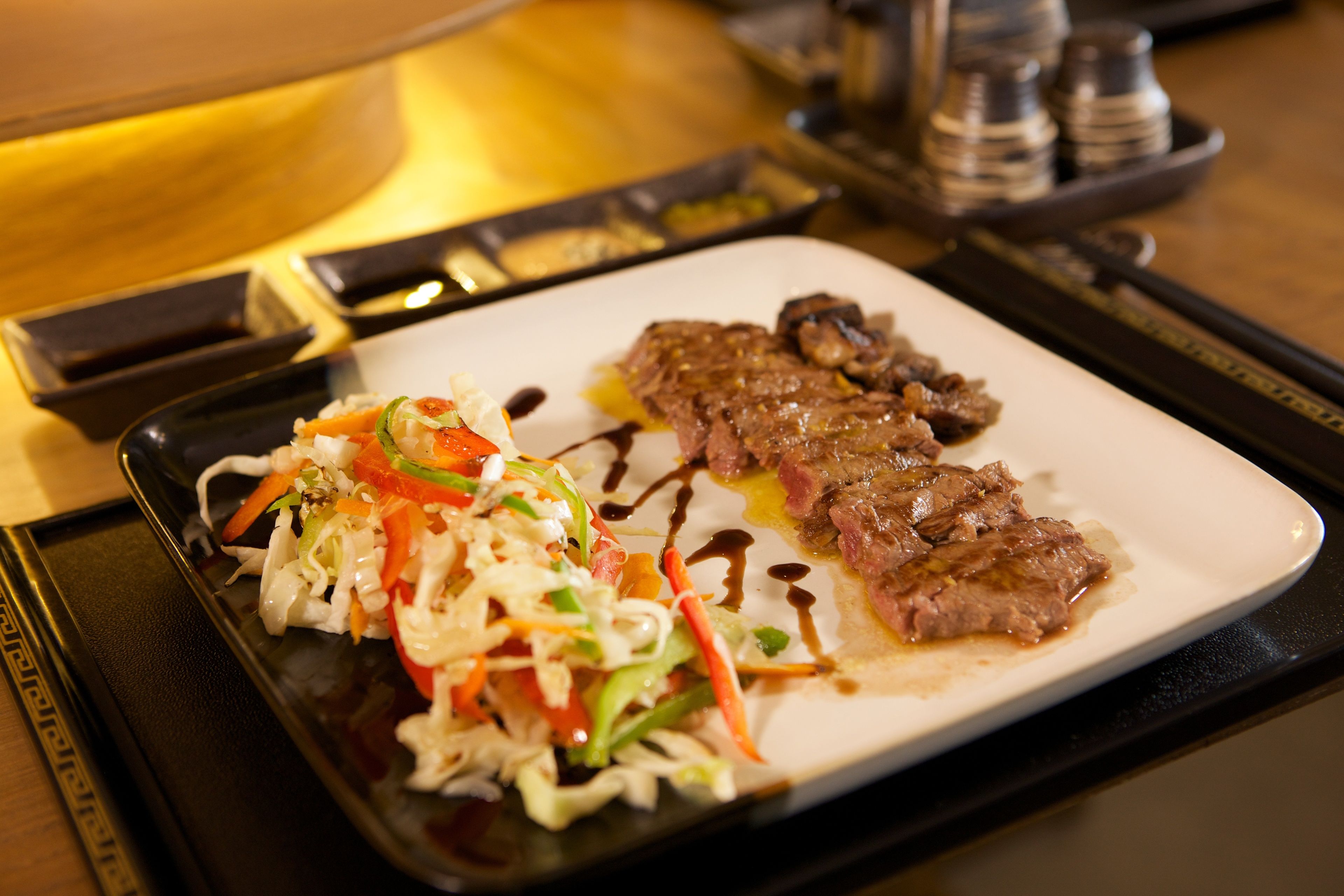 A plate of food with meat and vegetables on a tray.