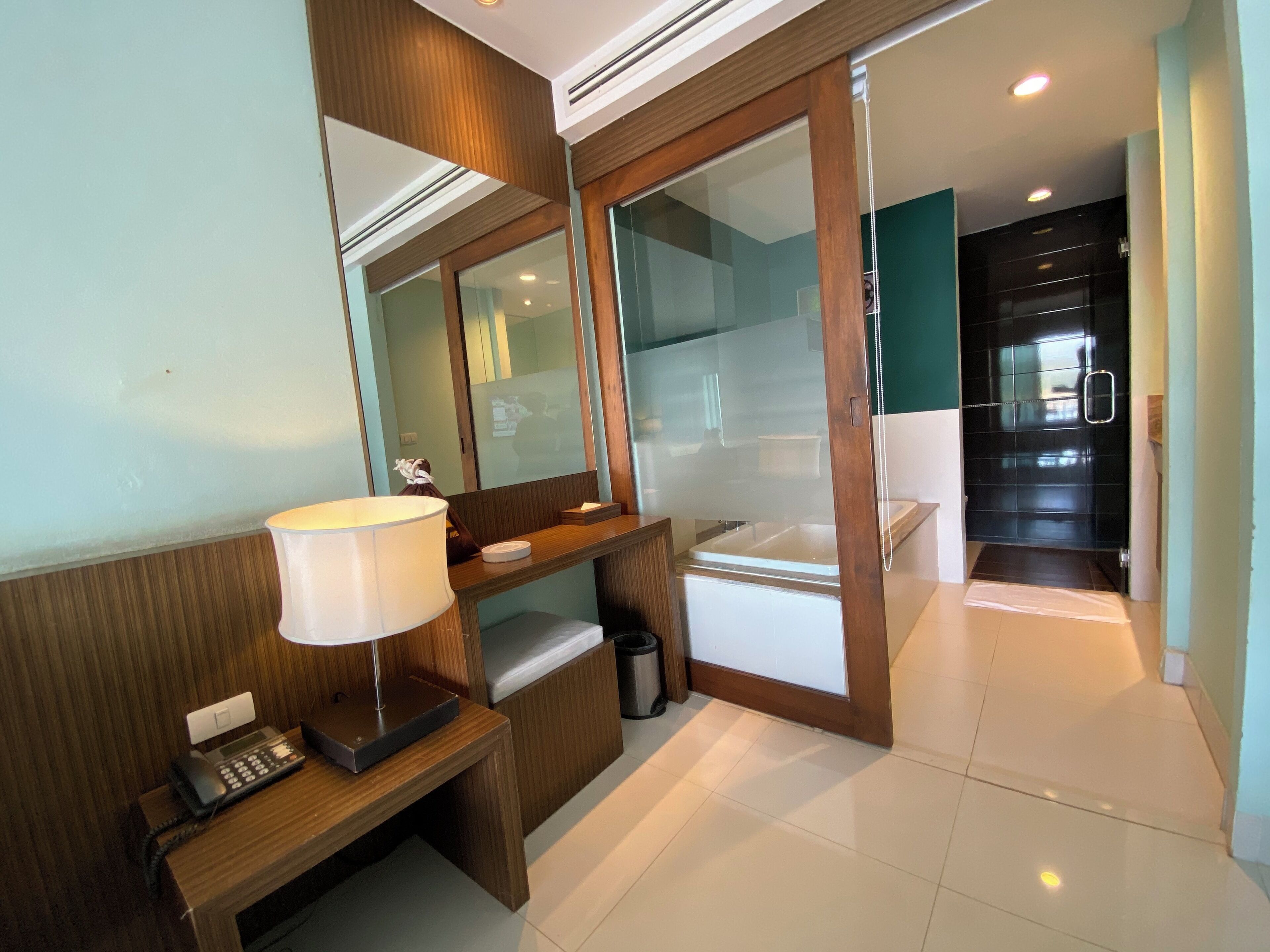 A modern bathroom with a vanity, mirror, and a shower area.