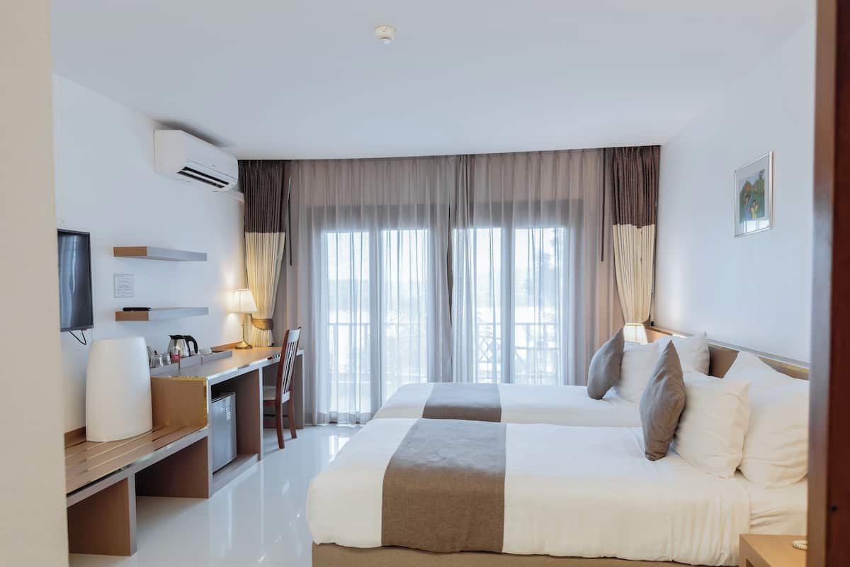 Una habitación de hotel con cama, escritorio, silla y televisor.