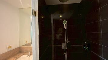A modern bathroom with a glass-enclosed shower, a sink, and a mirror.
