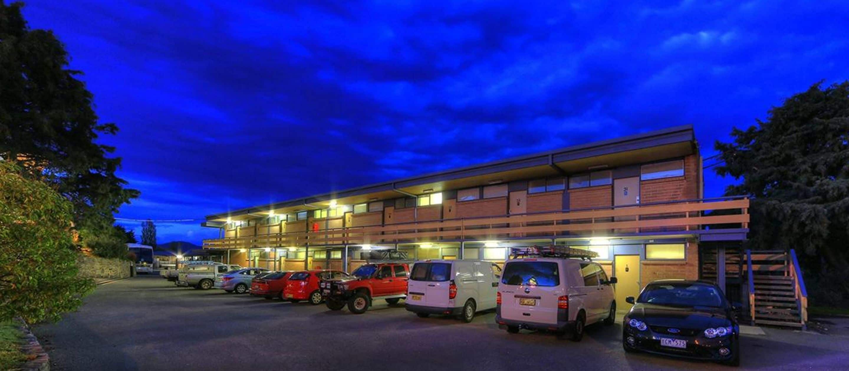 A multi-story building with several parking spaces and a staircase leading to an upper level.