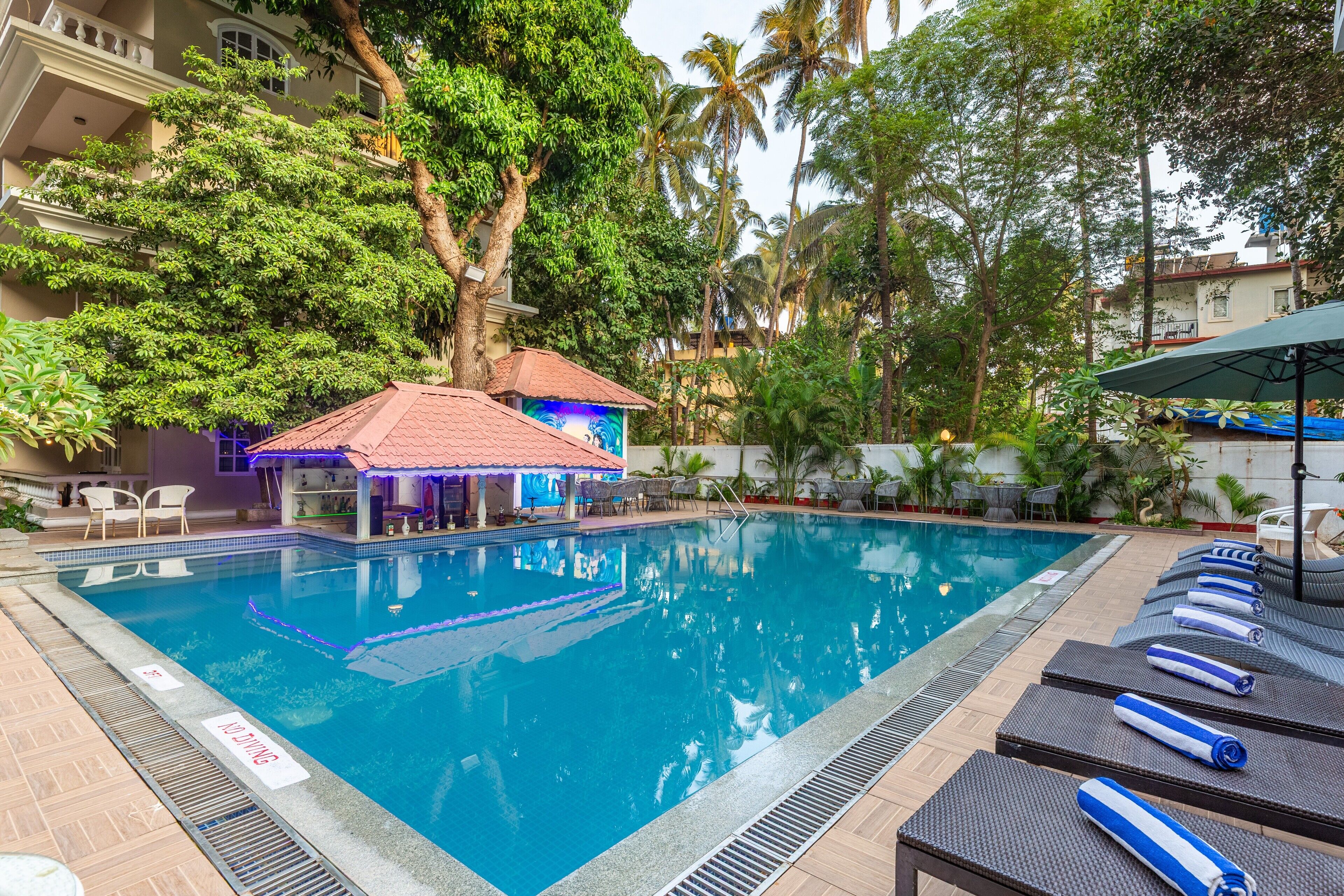 Ein Pool mit Liegestühlen und einer kleinen Bar.