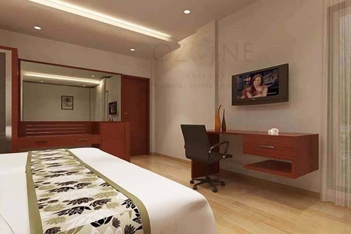 A hotel room with a bed, a desk, a chair, a TV, and a mirror.