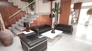 Een moderne woonkamer met een trap, leren banken, een salontafel en een potplant.