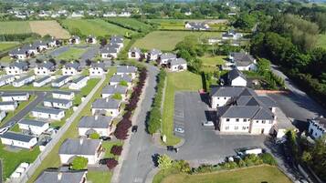 A residential area with detached houses, a central road, and a large open field.