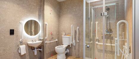 Un baño moderno con ducha envuelta en vidrio, un lavabo blanco y un inodoro.