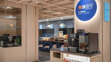 A modern coffee station with espresso machines and a coffee dispenser.