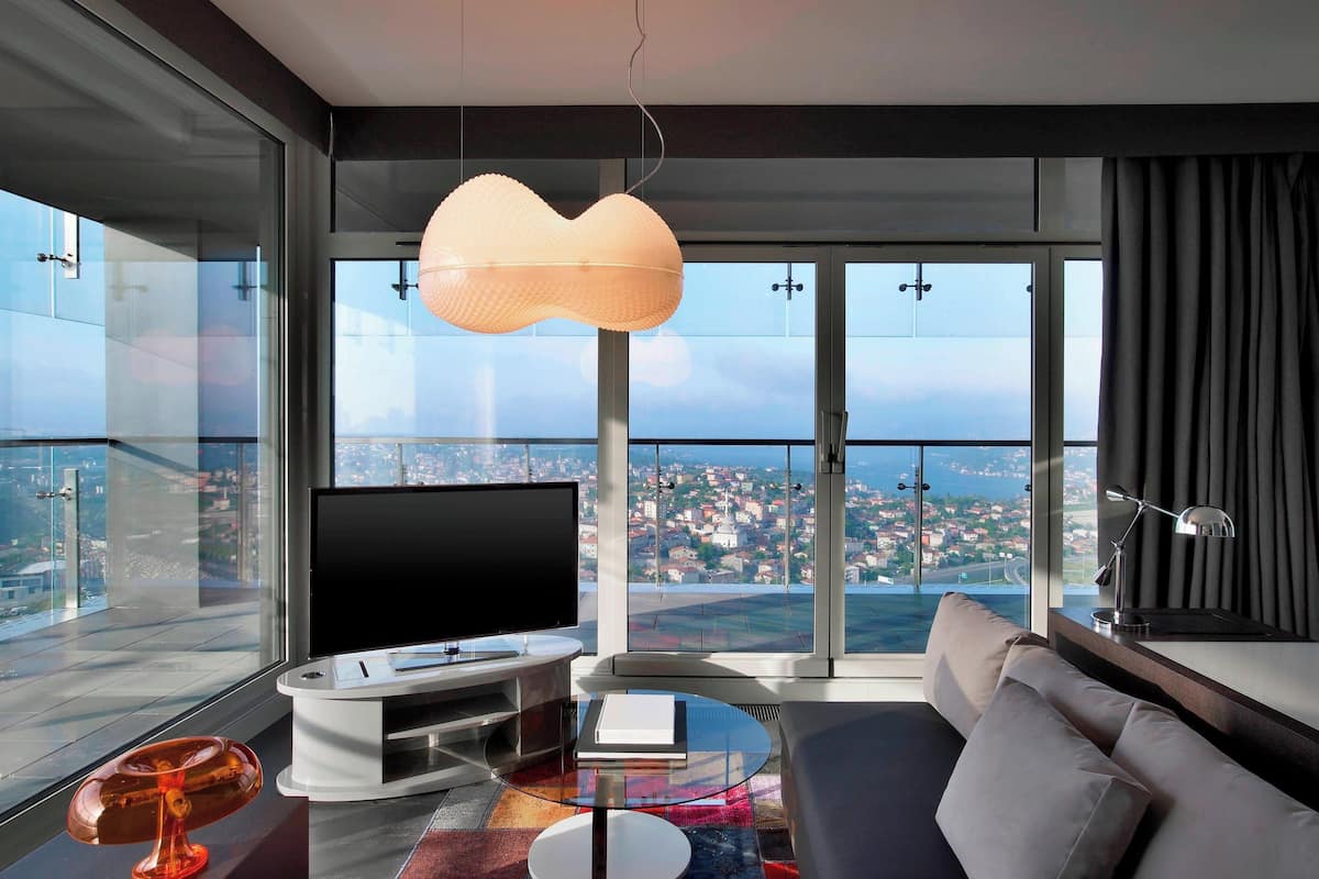 A modern living room with a large TV, a sofa, and a glass coffee table.