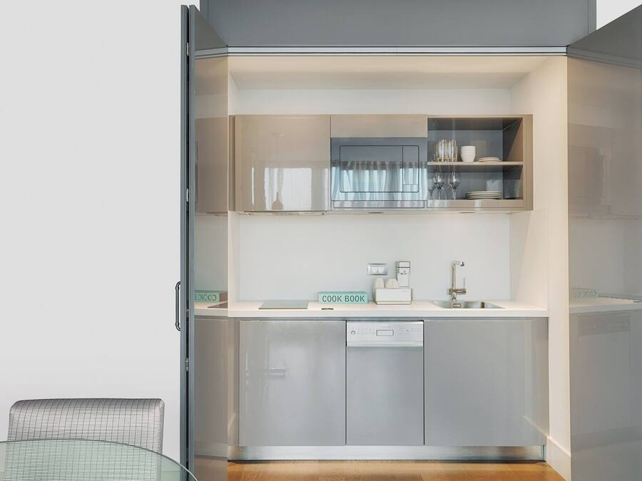 A modern kitchen with a glass door, a built-in dishwasher, and a cook book sign.