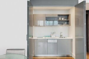 A modern kitchen with a glass door, a built-in dishwasher, and a cook book sign.