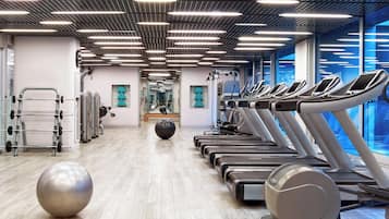 A modern gym with treadmills, exercise balls, and weightlifting equipment.
