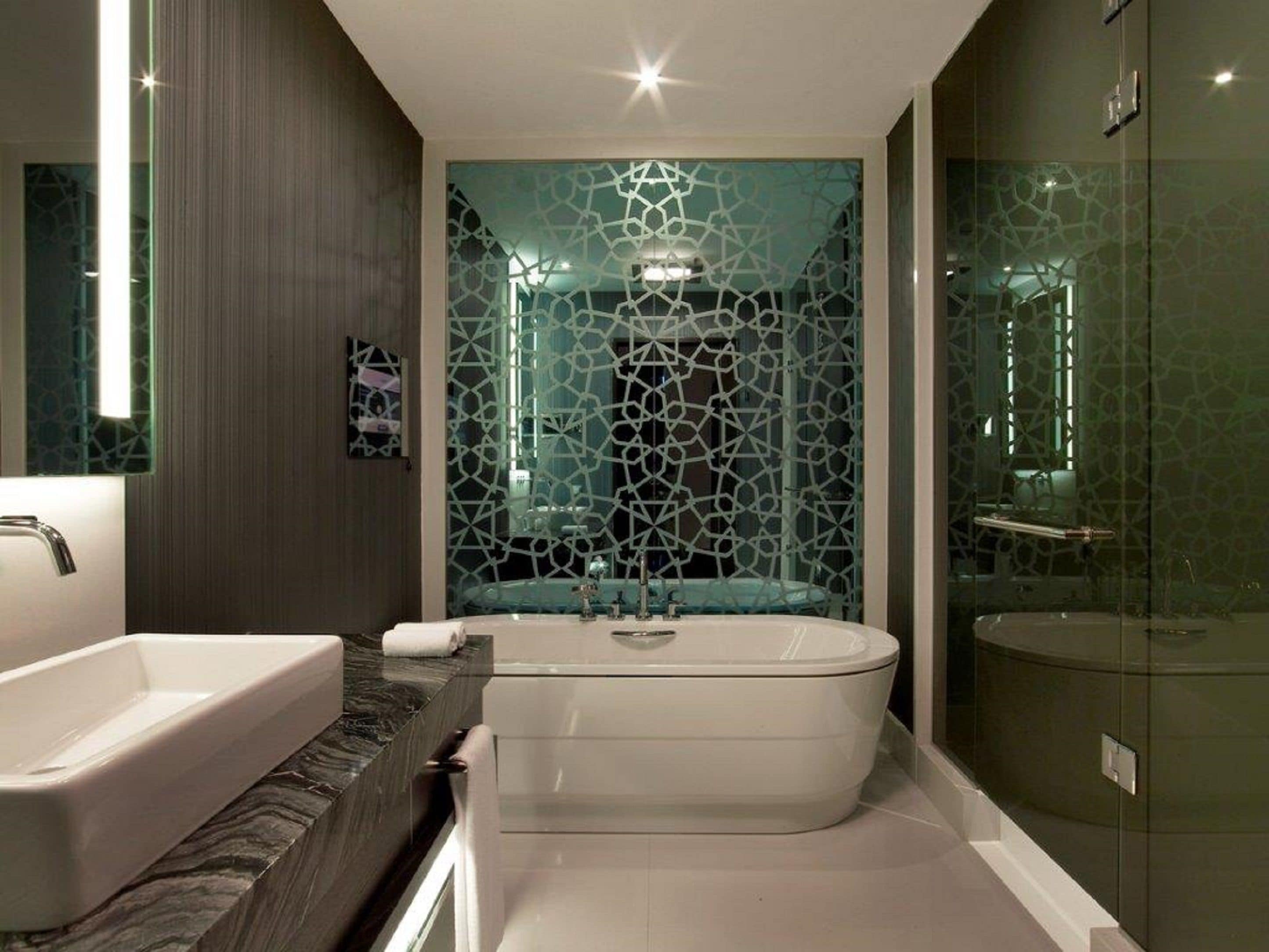 A modern bathroom with a freestanding bathtub, a glass-enclosed shower, and a marble countertop.