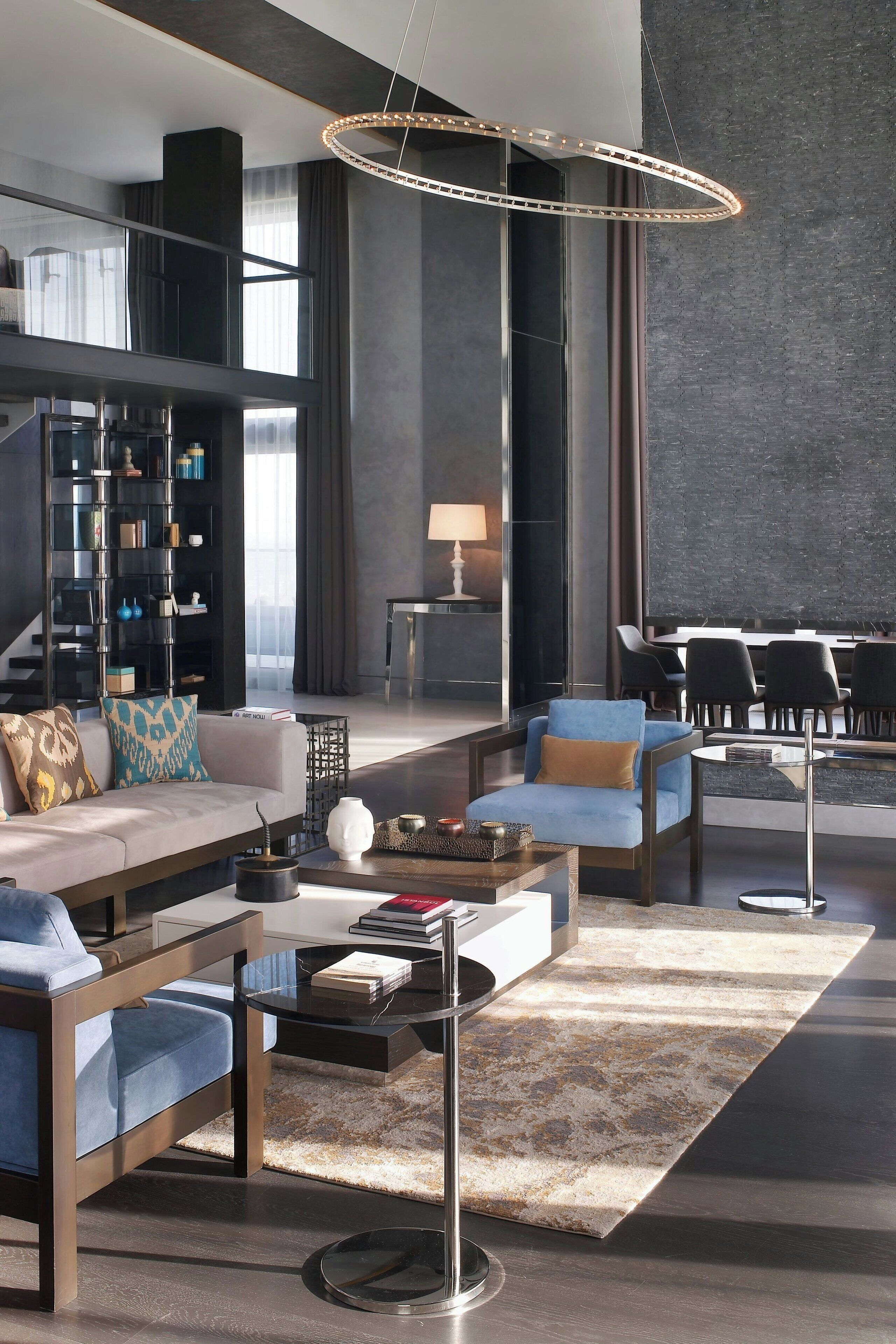 Una sala de estar moderna con un sofá, sillones, una mesa de centro y una estantería.