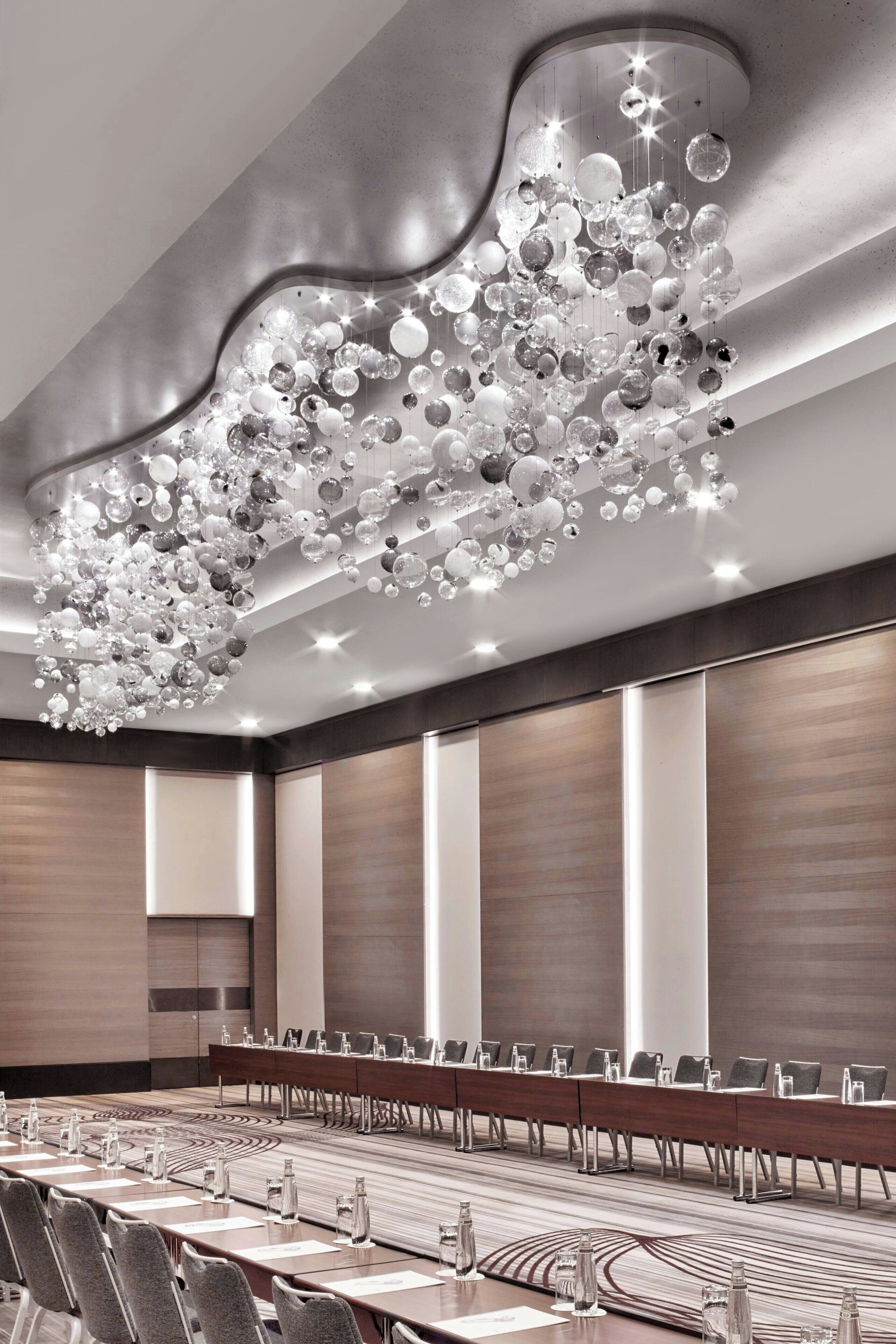 A conference room with a long table, chairs, and a unique chandelier.