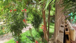 A garden with a wooden pergola, lush greenery, and red flowers. - ibis Tlemcen (Tlemcen)
