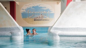 Una piscina con un murale raffigurante una spiaggia e una statua.