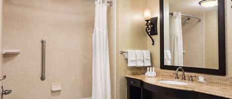 A modern bathroom with a bathtub, shower, and vanity with a sink.
