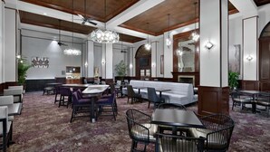 Eine großzügige Hotelhalle mit hohen Decken, einer zentralen Lounge und einer Bar.