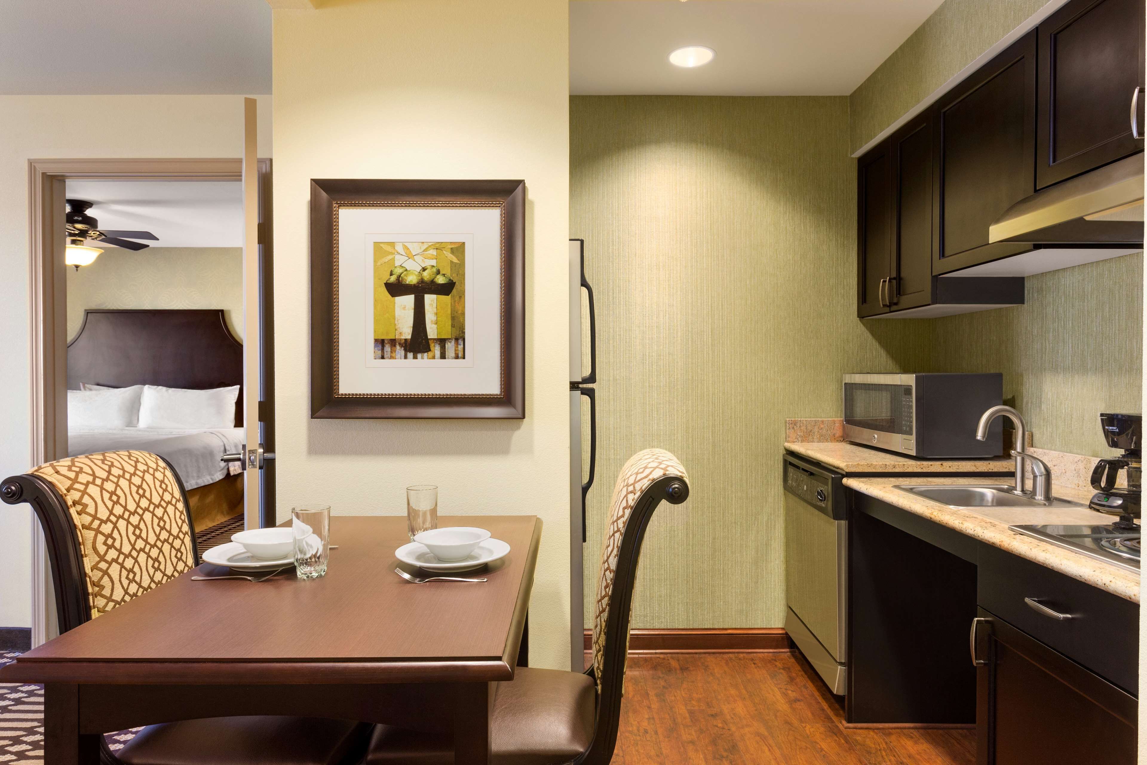A compact hotel room with a dining area, a microwave, and a dishwasher.