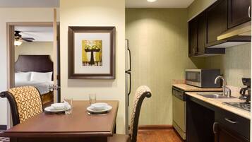 A compact hotel room with a dining area, a microwave, and a dishwasher.