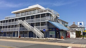 A multi-story hotel with a blue roof, a staircase, and a sign indicating it is a Sea Breeze location. - Sea Breeze Inn (Ocean City)