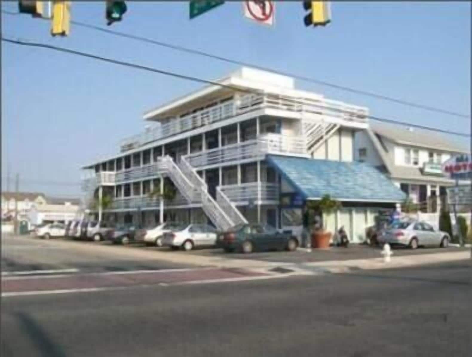 A multi-story building with a flat roof and a staircase leading to the entrance.