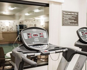 A fitness center with treadmills, a digital display, and a safety rules sign. - Sleep Inn & Suites Fort Campbell (Oak Grove)