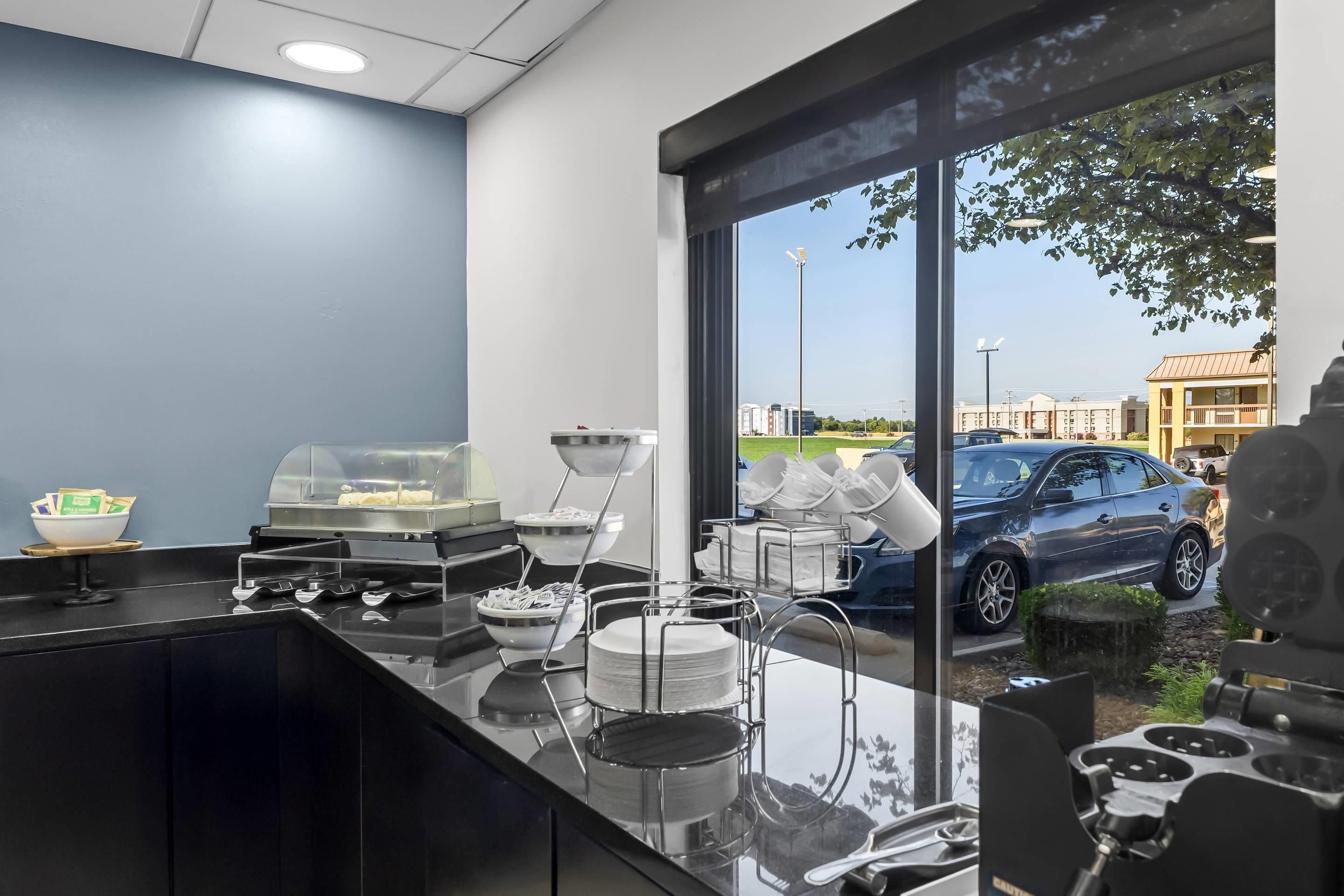 Une cuisine moderne avec une cloison en verre, un coin café et une vue sur le parking.