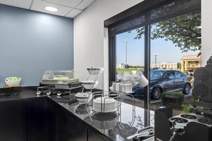 Una cocina moderna con separador de vidrio, estación de café y vista al estacionamiento.
