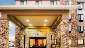 A Sleep Inn & Suites building with a stone facade, a covered entrance, and a sign indicating the hotel name.