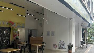 Un ristorante con posti a sedere all'aperto, un bancone in vista e un cartello sopra l'ingresso.