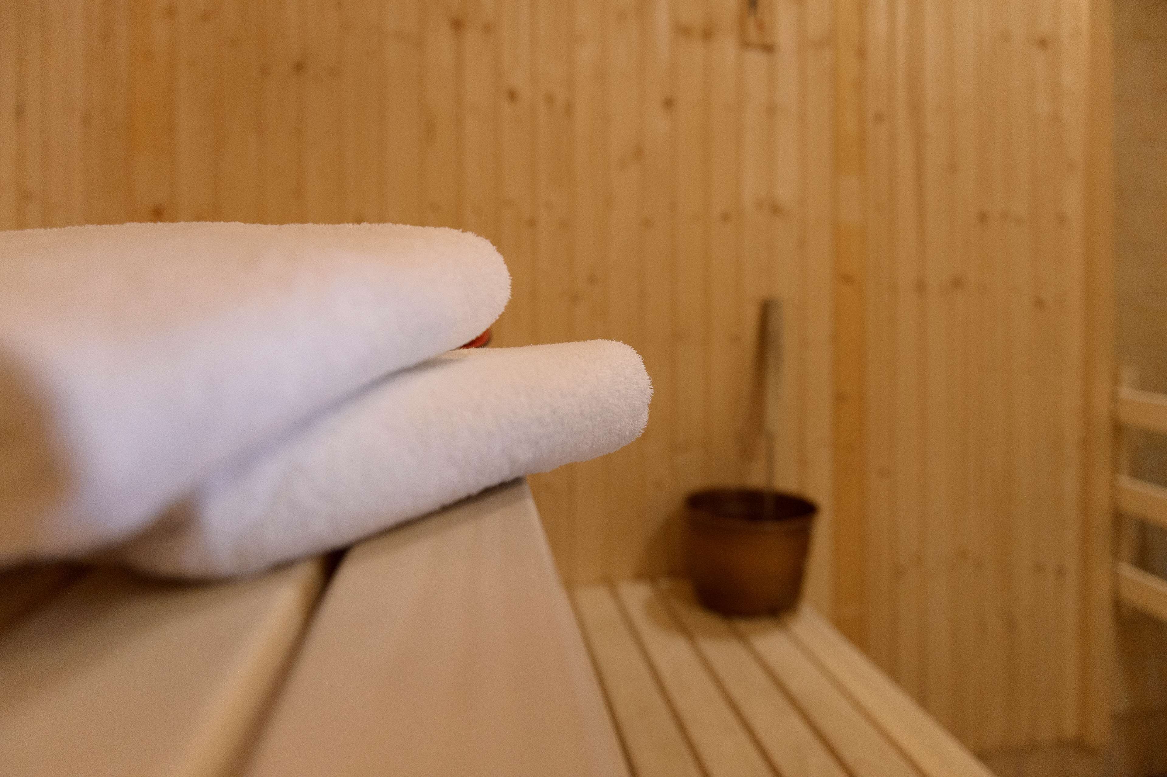 Una sauna in legno con una panca e un piccolo secchio di legno.