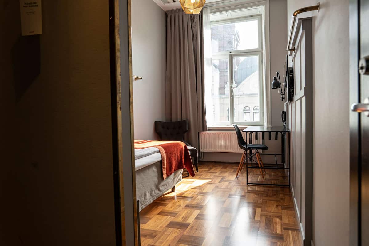Una habitación pequeña con una cama, un escritorio y una silla.