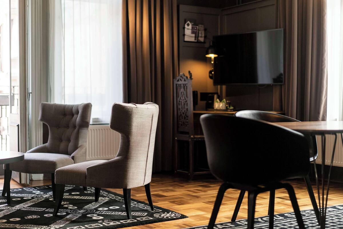 Una sala de estar moderna con un sofá, un sillón, una mesa de centro y un televisor.