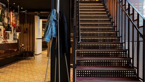 Una escalera con barandilla de metal y piso estampado.