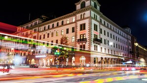 Un edificio histórico con un llamativo letrero 'Scandic', grandes ventanales y un estilo arquitectónico clásico.